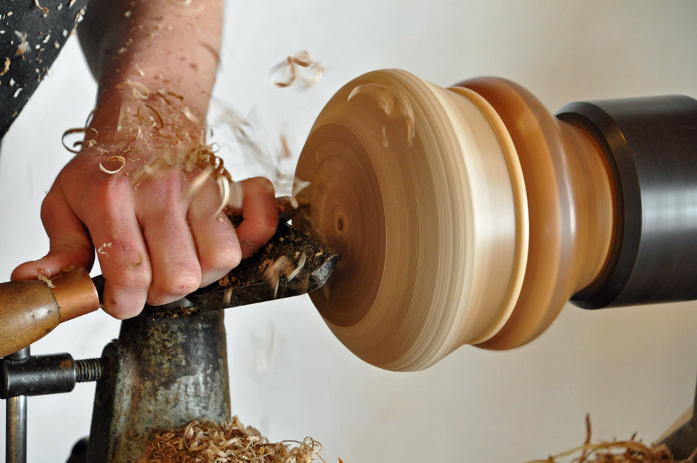 a woodworker using a lathe to woodturn