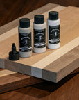 Three bottles of BOSSDOG products on a wooden surface