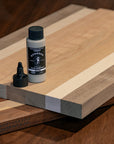 A cutting board with a bottle of BOSSDOG wood glue on top