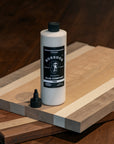 Bottle of BOSSDOG glue on a wooden surface