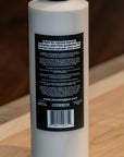 White bottle of BOSSDOG glue with a black label on a wooden surface