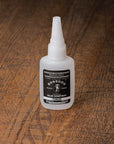 Bottle of BOSSDOG Glue on a wooden surface