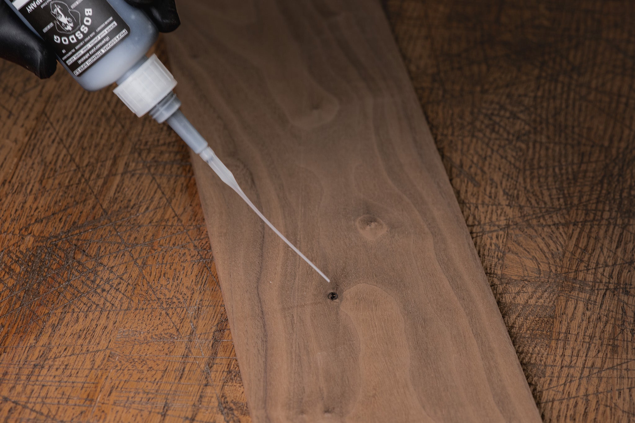 Wooden surface with a bottle applying glue.