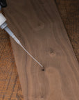 Wooden surface with a bottle applying glue.