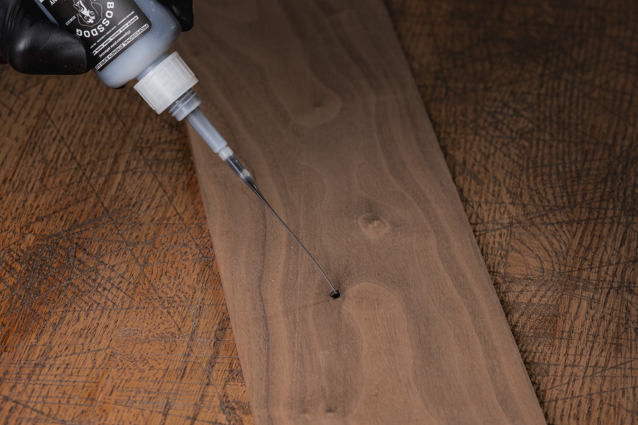 Wooden surface with a bottle of wood finish being applied