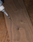 Wooden surface with a bottle of wood finish being applied