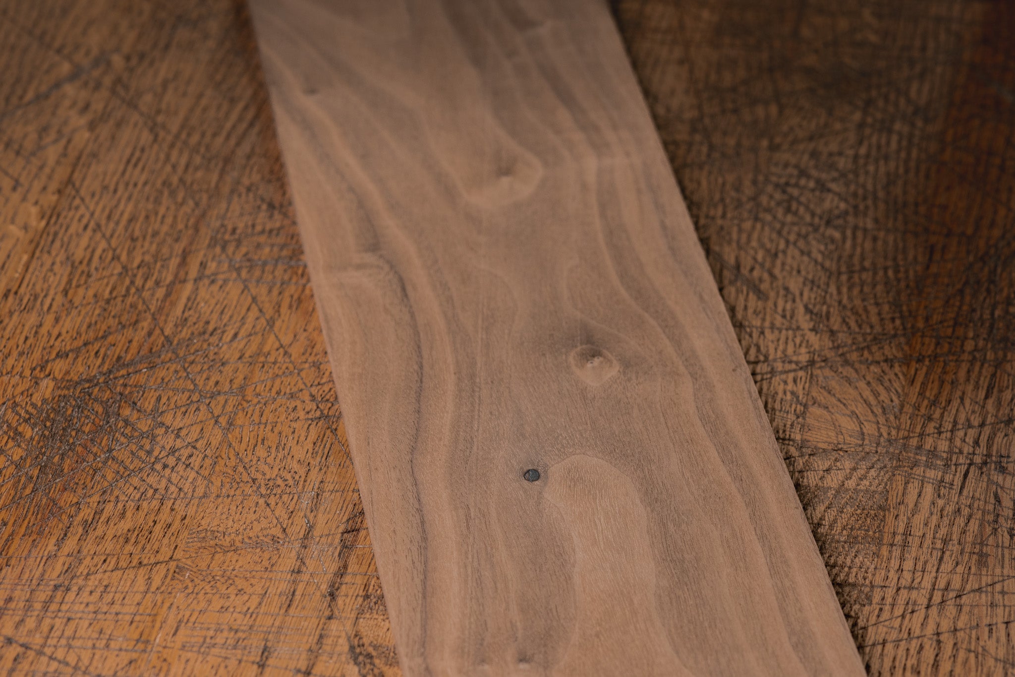 Close-up of a wooden board with visible grain on a textured surface