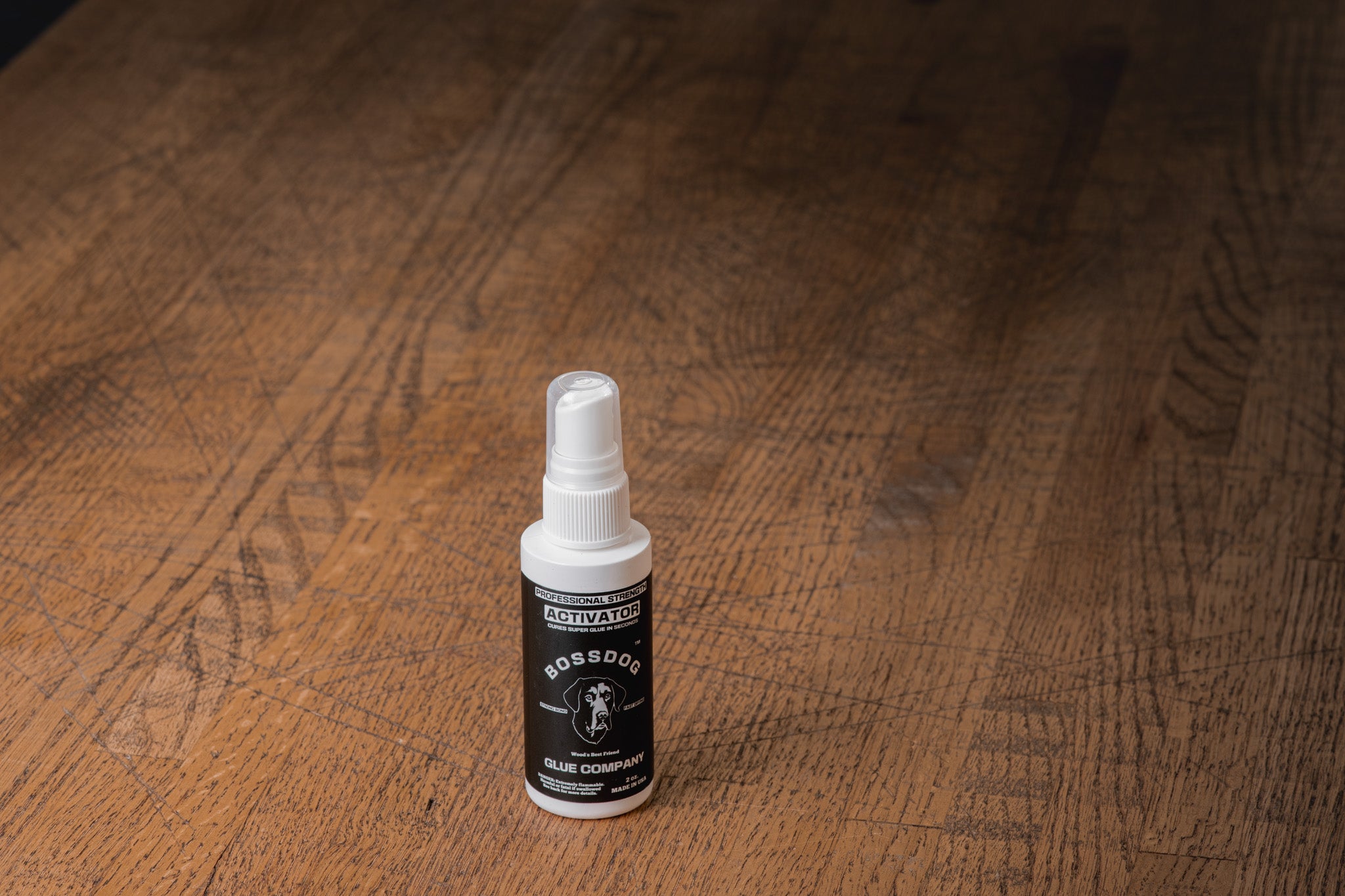 Small spray bottle of wood glue on a wooden surface
